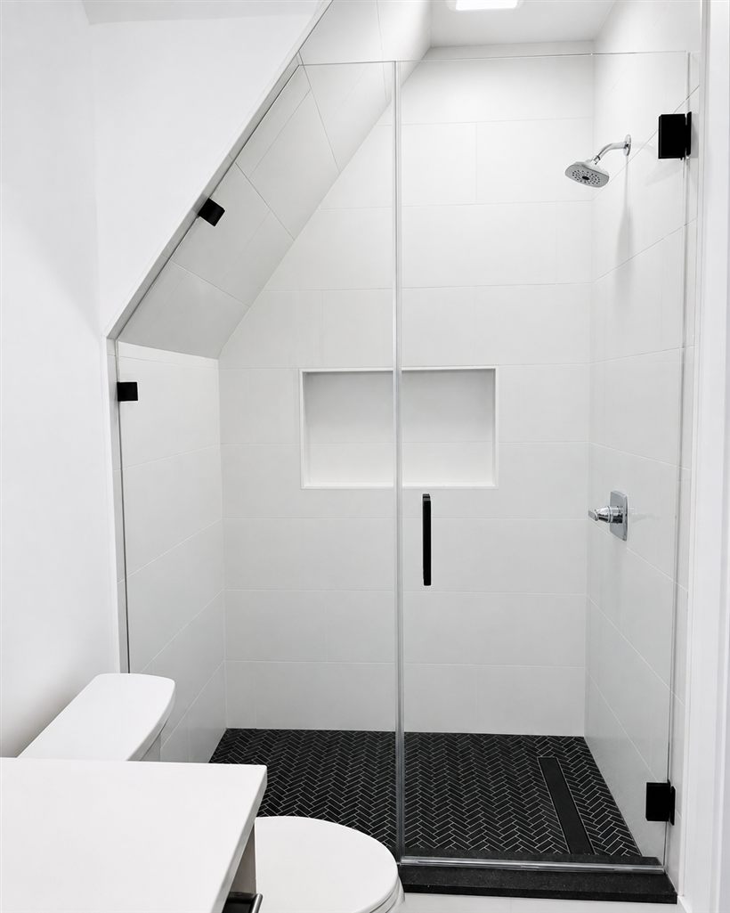 Frameless shower with angled-top glass on a sloped ceiling